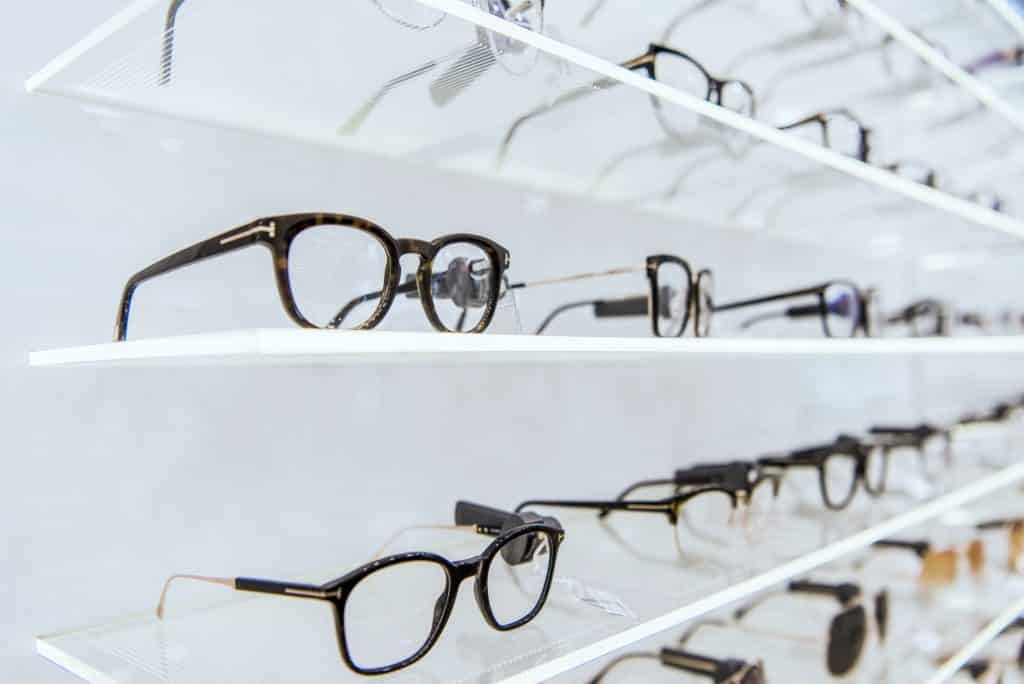 selective focus of white shelves with trendy glasses in ophthalmic shop