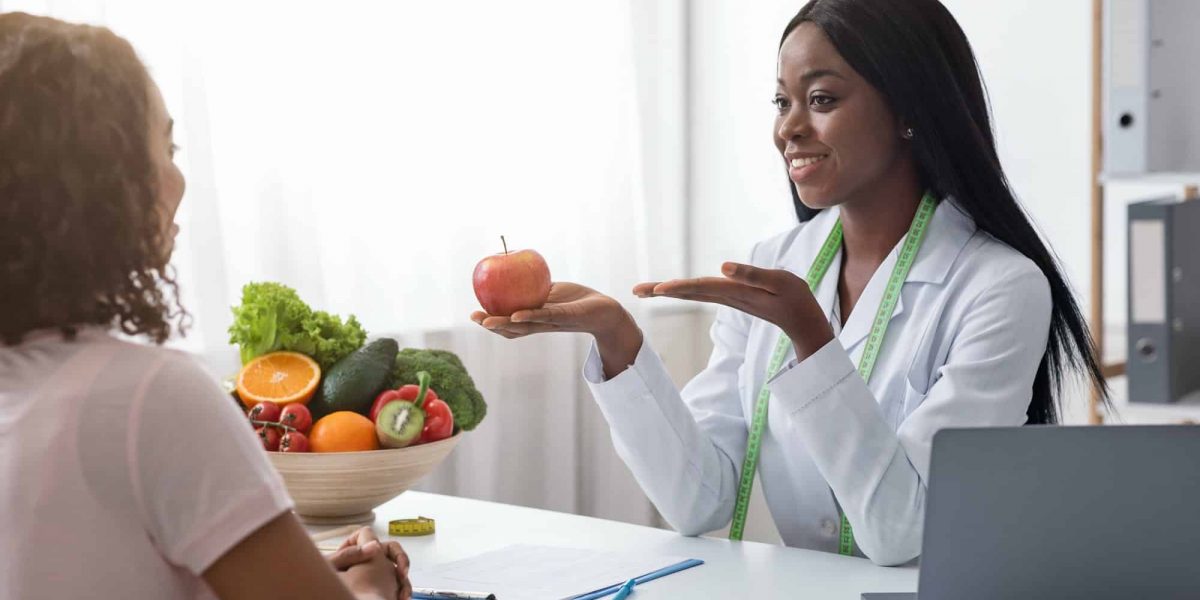 Positive african nutritionist recommending fresh fruits to eat